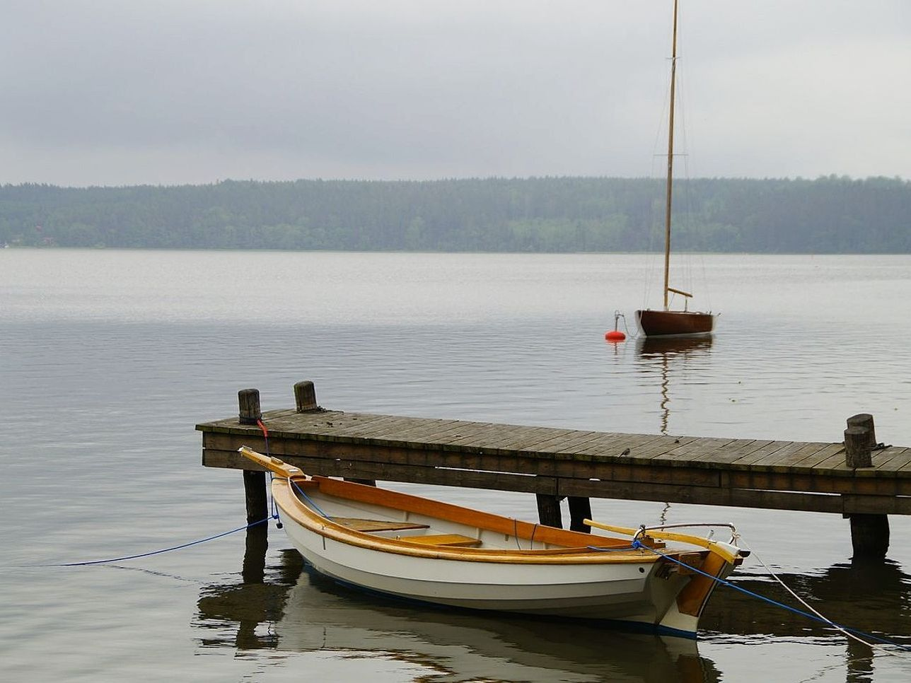 Three small dinghies lined up along the boat ramp